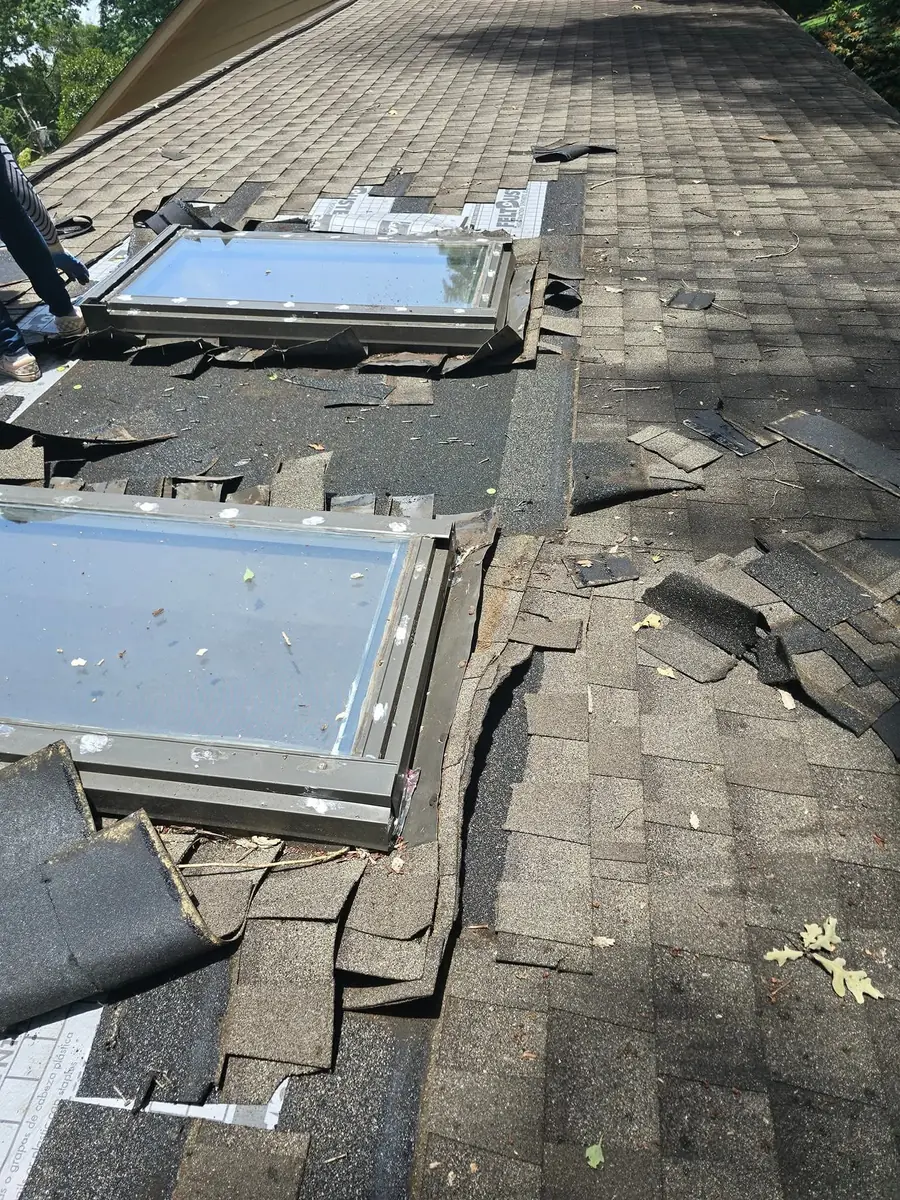Roof window area with lifted shingles before repair