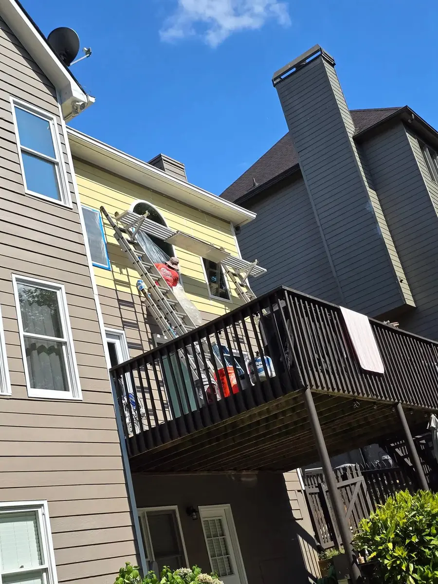 Siding repair underway near a deck and windows